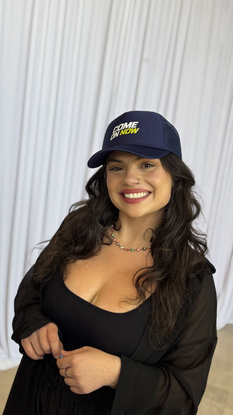 Woman wearing a custom navy mesh trucker hat personalized at a hat bar
